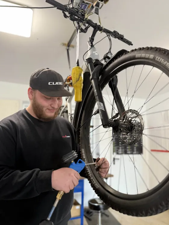 Werkstattmitarbeiter Jonas beim Schrauben an einem E-Bike bei Fahrrad Markus