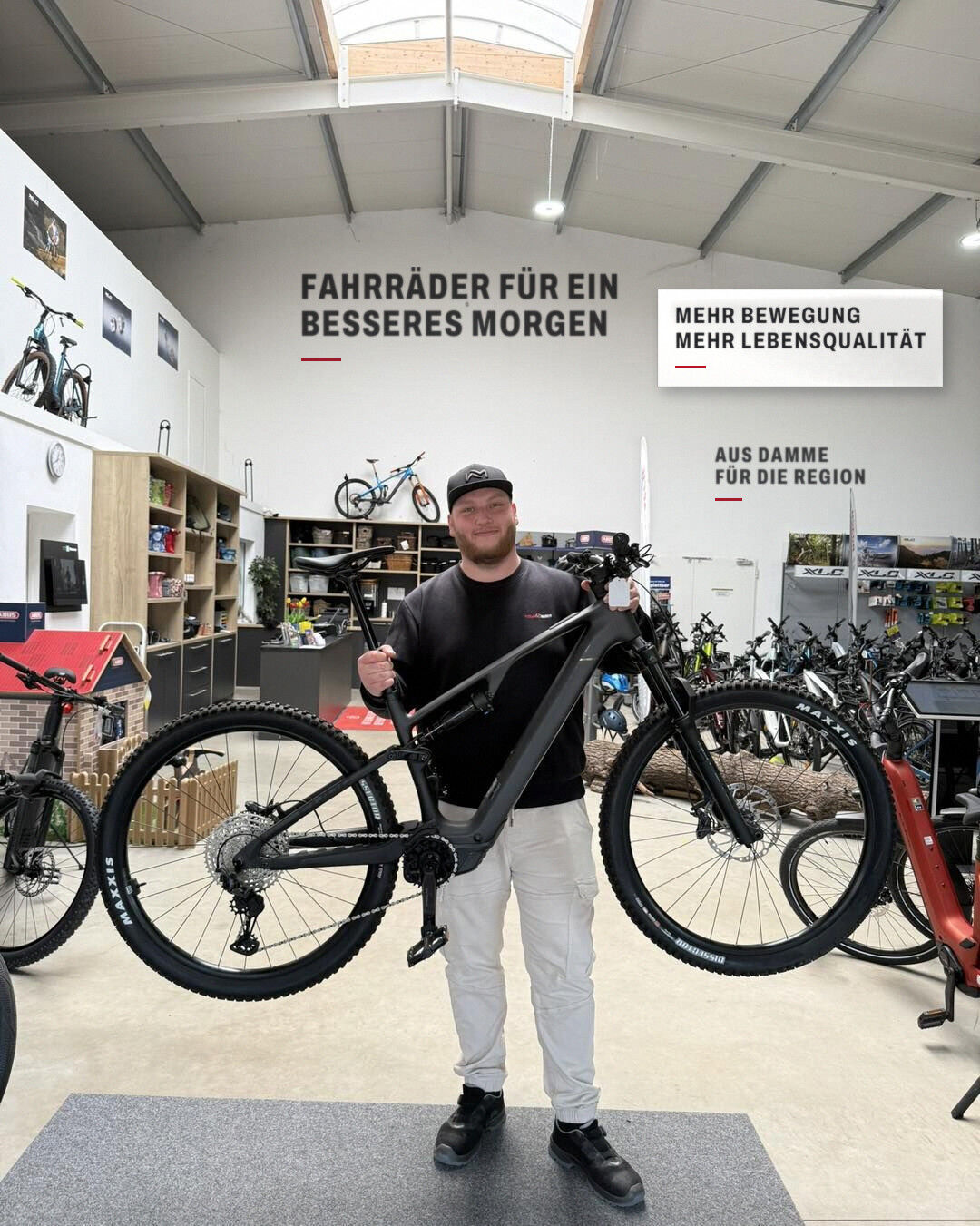 Jonas aus dem Team von Fahrrad Markus mit einem CUBE Stereo E-Bike im Laden in Damme
